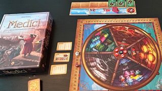 Medici box, board, tokens, and cards laid out on a dark surface